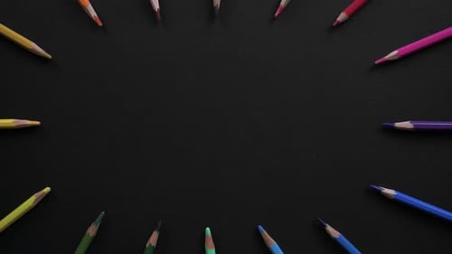 Wooden School Pencils of Different Colors Are Located on the Black Surface. Stop Motion Animation