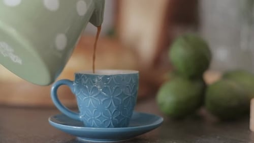 Man prepares Turkish coffee in green pot in the kitchen. Slow motion