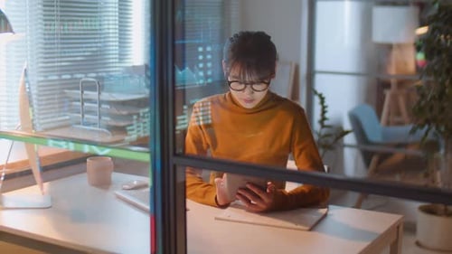 Asian Businesswoman Working on Tablet in Office at Night
