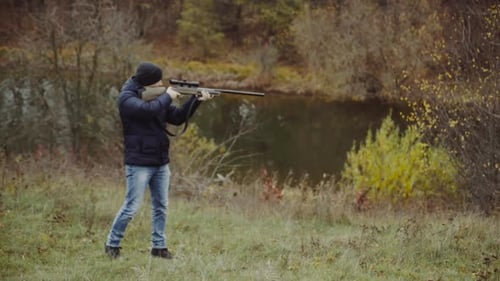 Jäger zielt auf Wildtiere. Nahaufnahme eines Jägers, der in der Herbstsaison auf sein Gewehr