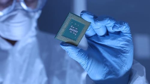 Mann im Reinraum hält Computer-CPU-Mikrochip hoch