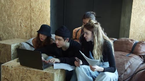 Four Young Adults Working Together on Laptop
