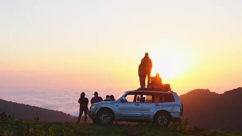 Friends Enjoying Mountain Sunrise Vista on Car Trip