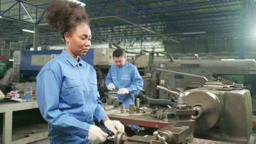 One professional young female worker works in metalwork manufacturing factory.