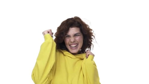 Woman Cheers and Celebrates in Yellow Hoodie