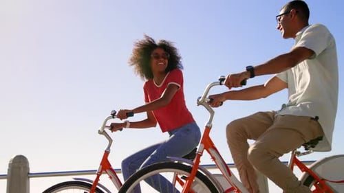 Couple riding bicycle on beach promenade in the sunshine 4k