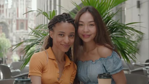 Two Young Women Posing at an Outdoor Cafe