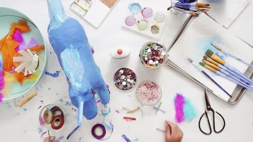 Time lapse. Step by step. Decorating painted paper mache unicorn with paper flowers and jewels.