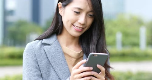 Woman Using Smartphone in Urban Park Setting