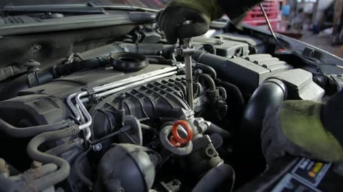 Mechanic Repairs Car Engine with Socket Wrench