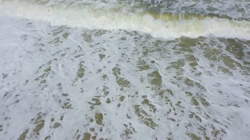 waves and white foam on the sand