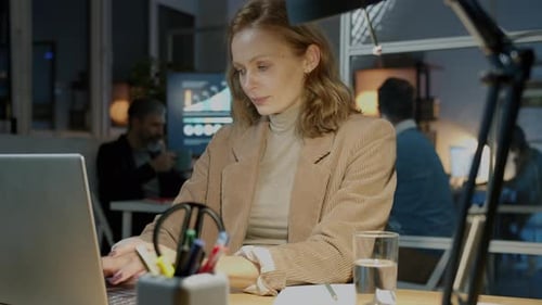 Woman Working Late on Laptop Talking on Cellphone