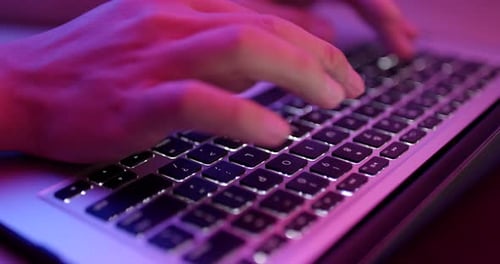 Tippen auf einer Notebook-Tastatur mit rosa Licht