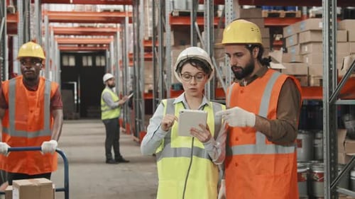 Female Manager with Tablet Talking to Warehouse Worker