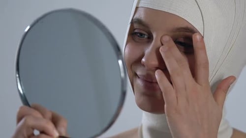 Woman Smiles with Head Wrapped in Bandages