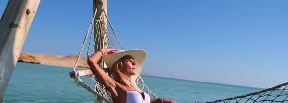 Travel and Vacation Concept Woman Relaxing on Hammock on the Beach