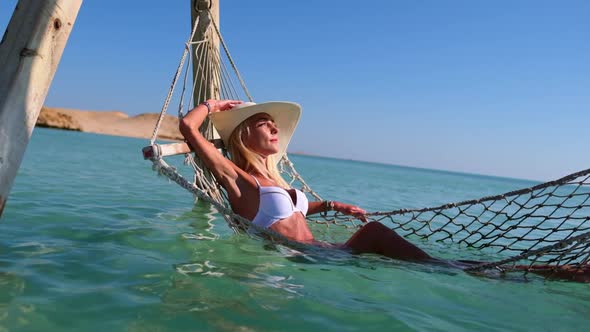 Travel and Vacation Concept Woman Relaxing on Hammock on the Beach