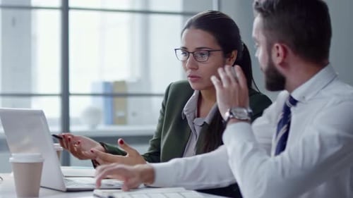 Professionals Working on Laptop and Talking at Office Desk