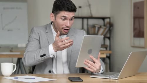 Adult Man Uses Tablet at Office Desk