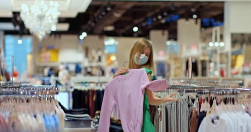 Cute Beautiful Girl Trying on Clothes in a Store on Sale Shopping