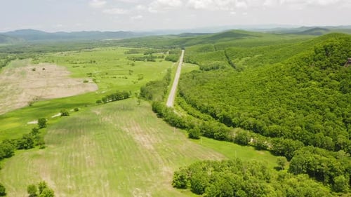 Vista con un Zumbido de un paisaje con bosques y campos verdes en un hermoso día soleado