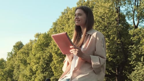 Woman Using Tablet Computer in Park