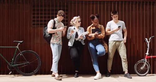 Friends Using Phones Outside in an Urban Setting