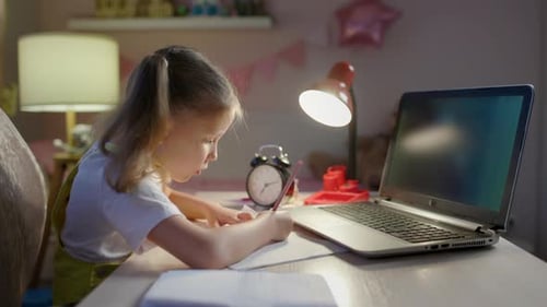 Child Concentrates on Homework at Night