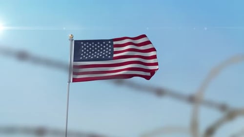 United States Flag Waving Behind Barbed Wire