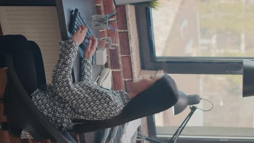 Woman Typing on Computer Keyboard at her Desk