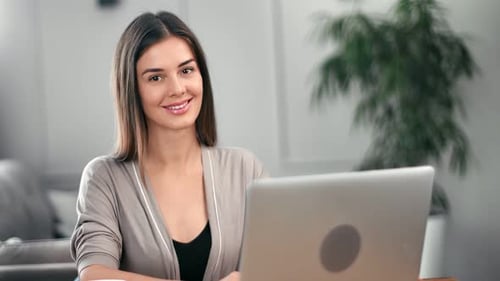 Freelancer Female Posing in Home Office at Table with Laptop