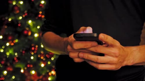 Hand Using Mobile Smart Phone with Colorful Light Celebration Background