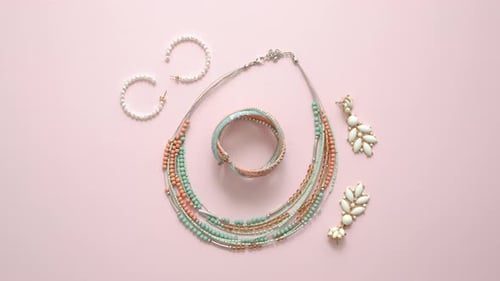 Woman Fashion Accessories. Jewelry. Earings and Necklace on Stylish Pastel Pink Background. Flat Lay