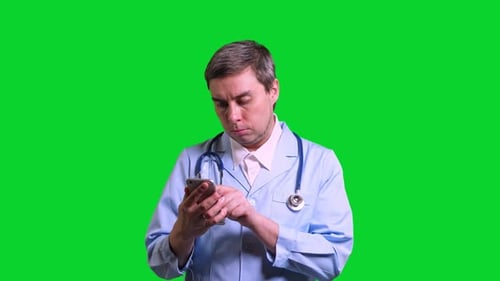 Young Doctor Using Smartphone on Green Chroma Key Background