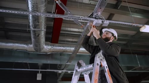 Electrician Working on Wires in Industrial Workplace