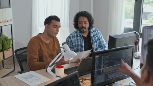 Team of Programmers Discussing Documents in Office