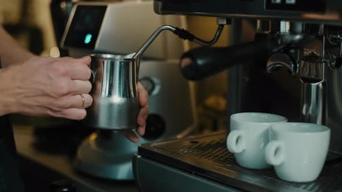 Barista Steaming Milk for Delicious Coffee Drinks