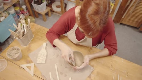 Woman Creating Ceramic Bowl in Pottery Workshop