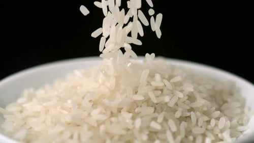 White Rice Grains Pouring into Bowl