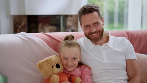 Father and Daughter Smiling on a Couch