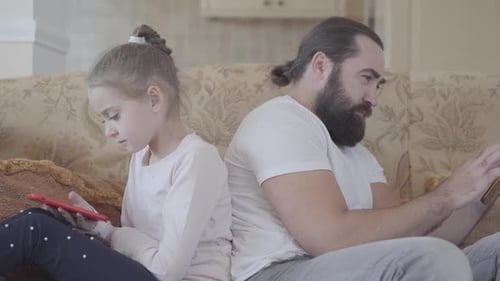Bearded Man and Girl Sit With Mobile Devices