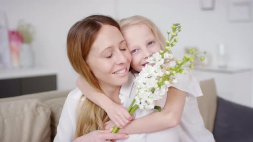 Loving Daughter Hugs Mother with White Flowers
