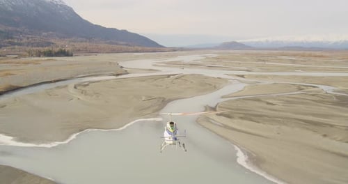 Helicopter Flies Over Braided River Wilderness