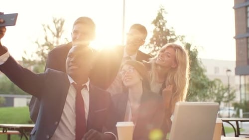 Business Team Smiles for Selfie at Outdoor Cafe
