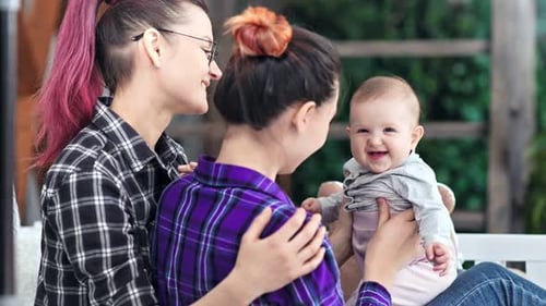 Smiling Baby with Two Young Adults