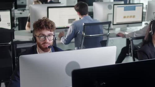 Close Up Portrait of a Technical Customer Support Specialist Talking on a Headset While Working on a