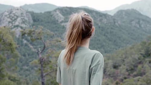 Rear View of a Woman Alone on the Mountain High Enjoying the View