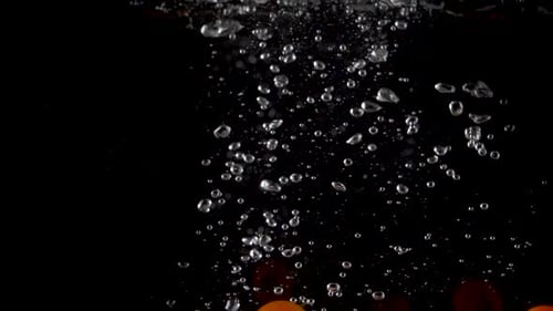 Closeup of fresh and health cherry tomatoes falling into clear water with big splash