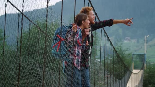 Couple Exploring Mountain Views From Suspension Bridge
