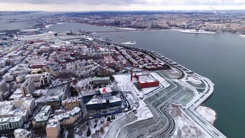 Snowy Cityscape Aerial View along Frozen River in Winter